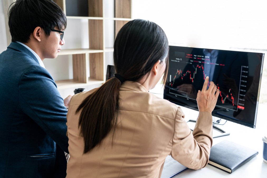 acionistas - duas pessoas acompanhando dados em um computador